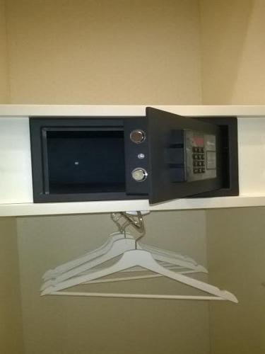 a microwave oven on a shelf with a hanger at Estate4home - Surreo Luxury B&b in Sorrento