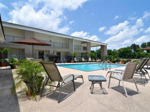 a group of chairs sitting next to a swimming pool at Motel 6-Luling, LA in Luling