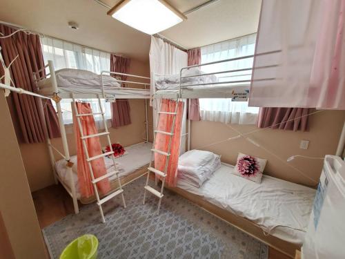 a dorm room with two bunk beds in it at Fukuoka Guest House Jikka in Fukuoka