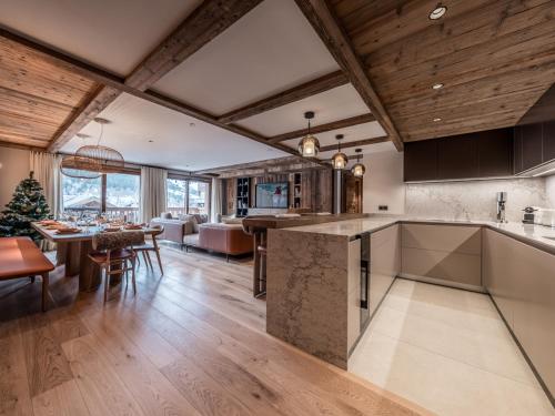 une cuisine ouverte et un salon avec un sapin de Noël dans l'établissement Appartement de luxe, 3 chambres, cheminée, conciergerie 5*, ski room, non-fumeur - FR-1-613-124, à Les Allues