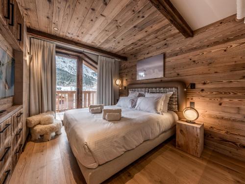 une chambre avec un lit dans une pièce aux murs en bois dans l'établissement Appartement de luxe, 3 chambres, cheminée, conciergerie 5*, ski room, non-fumeur - FR-1-613-124, à Les Allues