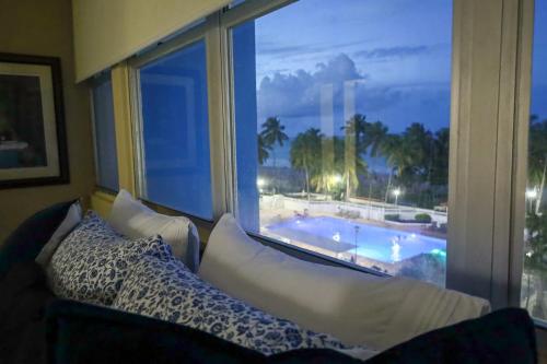 a room with a couch and a large window with a pool at Mi estadía in San Juan