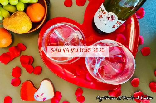 a red table with hearts and a bottle of wine at Agri-alloggio le Poscole Al Canton in Castelgomberto