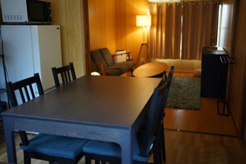 a kitchen with a table and chairs and a refrigerator at 吉田邸　古民家の落ち着いたお家 in Ichimonji