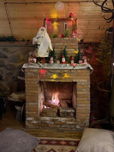 a fireplace in a room with a christmas decoration at AURA Cottages in Stepantsminda