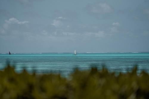a view of the ocean with boats in the water at The Loop Beach Resort in Jambiani