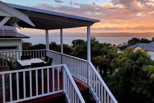 a balcony of a house with a view of the ocean at Bay Vista Cottage by the BnB Collection in Albany