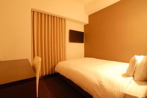 a hotel room with a bed and a table at AB Hotel Komaki in Komaki