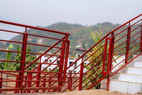 a red metal railing on the side of a building at Kivu Greenstars Apartment in Gisenyi