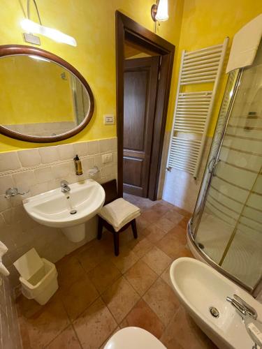 a bathroom with a sink and a toilet and a mirror at Le Calvie, country house in Camerino