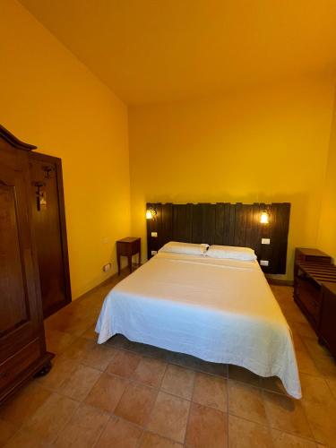 a bedroom with a white bed and yellow walls at Le Calvie, country house in Camerino