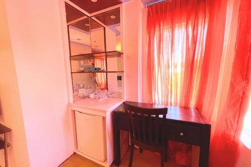 a room with a desk and a table and a chair at Here Innstead Boracay in Boracay
