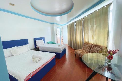 a hotel room with two beds and a couch at Here Innstead Boracay in Boracay
