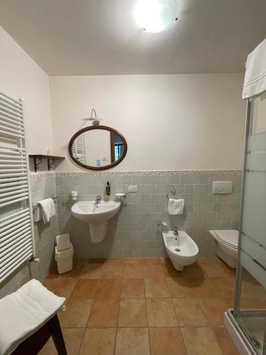 a bathroom with a sink and a toilet and a mirror at Le Calvie, country house in Camerino