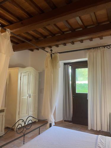 a bedroom with a bed and a window at Le Calvie, country house in Camerino