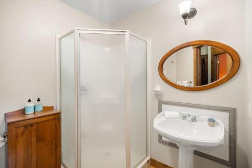 a bathroom with a sink and a shower with a mirror at Les Manoirs 3bdrs Near Village in Mont-Tremblant