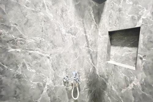 a bathroom with a marble wall with a sink at RedDoorz Syariah at Florensa Banda Aceh in Lamglumpang