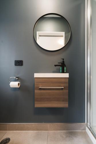 a bathroom with a sink and a mirror at 3 BDR CBD Get Away in Auckland