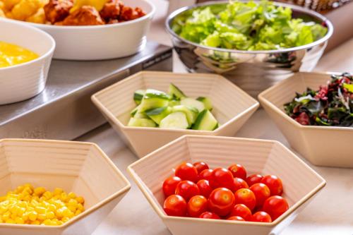 a table topped with bowls of different types of vegetables at Tokyu Stay Kanazawa in Kanazawa