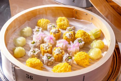 a wooden bowl filled with uncooked food with cheese at Tokyu Stay Kanazawa in Kanazawa
