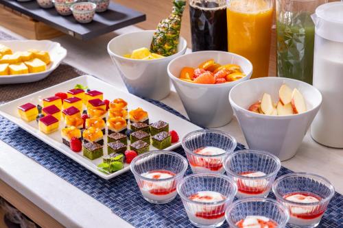 a table with a plate of food and bowls of fruit at Tokyu Stay Kanazawa in Kanazawa