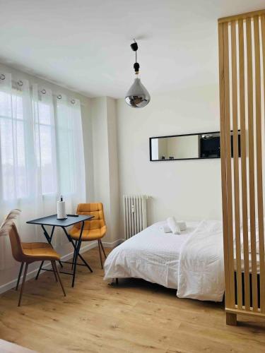 a bedroom with a bed and a table and chairs at Appartement plein centre ville d alfortville in Alfortville
