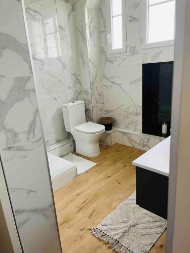 a bathroom with a toilet and marble walls at Appartement plein centre ville d alfortville in Alfortville
