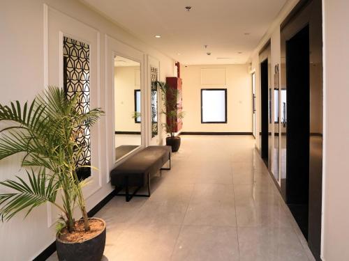 a hallway with a chair and a plant at Hotel One Vogue Mall 35 Rawalpindi in Rawalpindi
