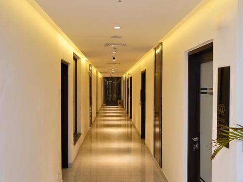 a long corridor with white walls and a long hallway at Hotel One Vogue Mall 35 Rawalpindi in Rawalpindi