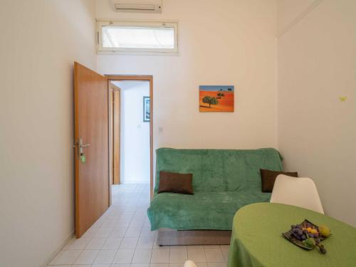 a living room with a green couch and a table at LaidBack Apartments - Comfort One Bedroom Apartment with Balcony and Sea View Green in Orebić