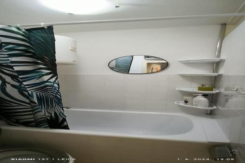 ein weißes Bad mit einer Badewanne und einem Spiegel in der Unterkunft Apartment Sunrise in Dugi Rat