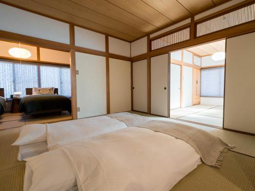 a bedroom with a large bed with a large window at お宿Gａｎ錦町 in Takamatsu