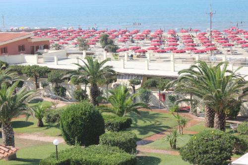 a view of a beach with red umbrellas at Hotel Calypso in Ardea