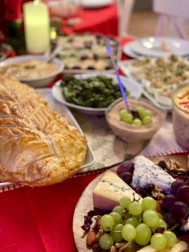 a table topped with plates of food with grapes and bread at Pension Casa del Sol Predeal in Predeal
