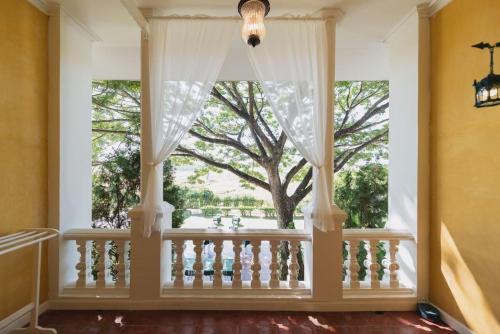 a window in a house with a tree outside at The Cathay Resort & Spa in Chiang Mai