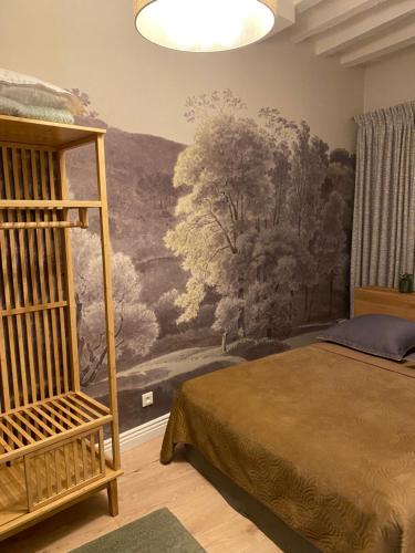 a bedroom with a painting on the wall at Les Hortensias in Canly