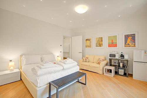 a white living room with a couch and a table at Les Suites di Sara 3 and 5 - Happy Rentals in Riva del Garda