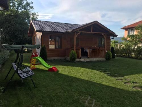 a small house with a playground in the yard at Къщи за гости Михайлови in Sapareva Banya