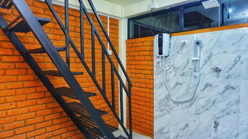 a shower in a bathroom with a brick wall at Sigiri SAAT Cabana in Sigiriya
