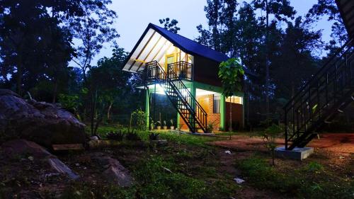 a house with a staircase leading up to it at Sigiri SAAT Cabana in Sigiriya