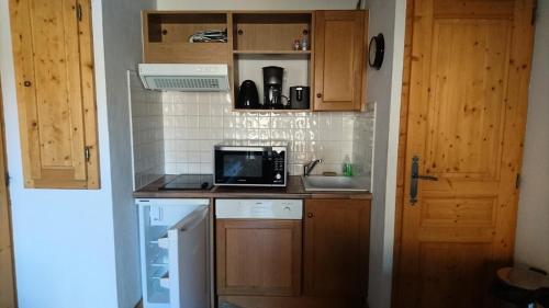 une petite cuisine avec un évier et un micro-ondes dans l'établissement Edelweiss Chalets De La Vallee D'or - 2 pièces 4 personnes 3 exposé Nord MAE-9334, à Valloire