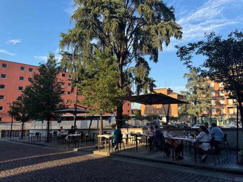 a group of people sitting at tables with umbrellas at Hotel Astoria in Fidenza
