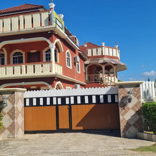 a large house with a wooden garage door at Paradise Place Grande King in Cave Hill