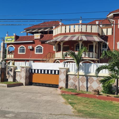 a large house with a white fence in front of it at Paradise Place Grande King in Cave Hill