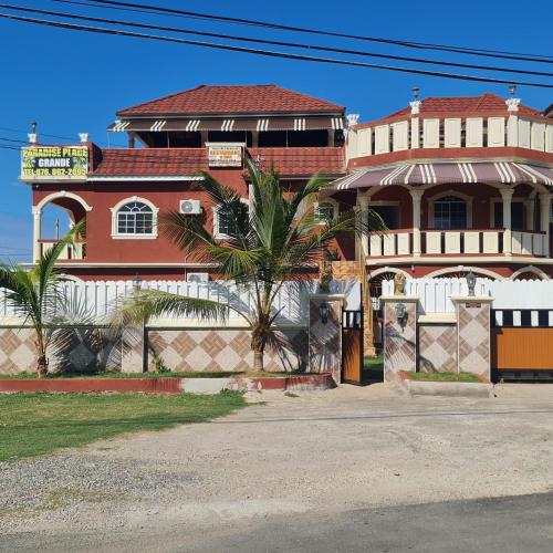 a building with a palm tree in front of it at Paradise Place Grande King in Cave Hill
