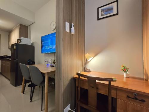 a room with a desk and a table with chairs at 1BR Condotel with Balcony at FAME Residences #FM64 in Manila