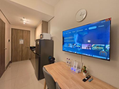 a large flat screen tv hanging on a wall at 1BR Condotel with Balcony at FAME Residences #FM64 in Manila