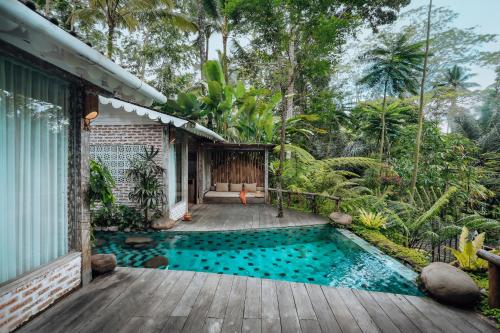 a house with a swimming pool and a wooden deck at Pramana Giri Kusuma in Payangan