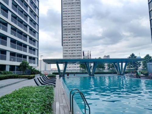 a swimming pool with a bridge in a city at 1BR Condotel with Balcony at FAME Residences #FM64 in Manila