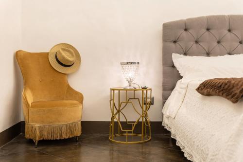 a bedroom with a bed and a hat and a side table at Dimora D'Incanto in Ragusa